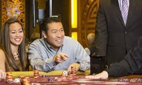 Dealer kasino langsung sedang menjalankan permainan baccarat secara online dengan interaksi real-time